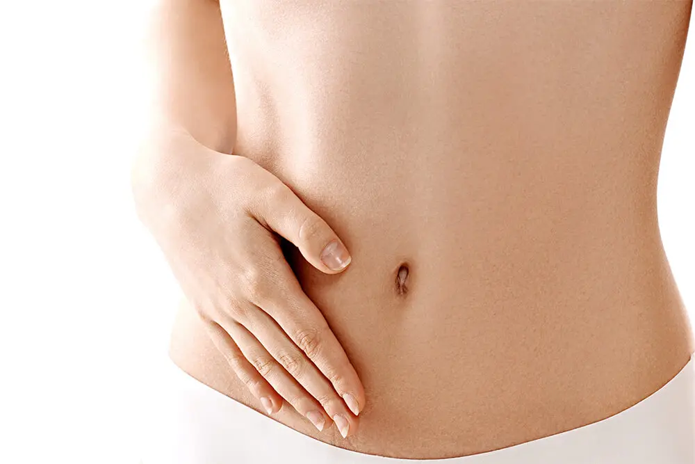 A woman is holding her stomach and hands